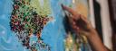 A world map with many pins stuck in it